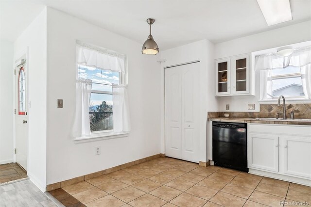 1648 S Cole St Unit B7, Lakewood, CO 80228 - kitchen featuring dishwasher, white cabinetry, glass insert cabinets, hanging light fixtures, and decorative backsplash