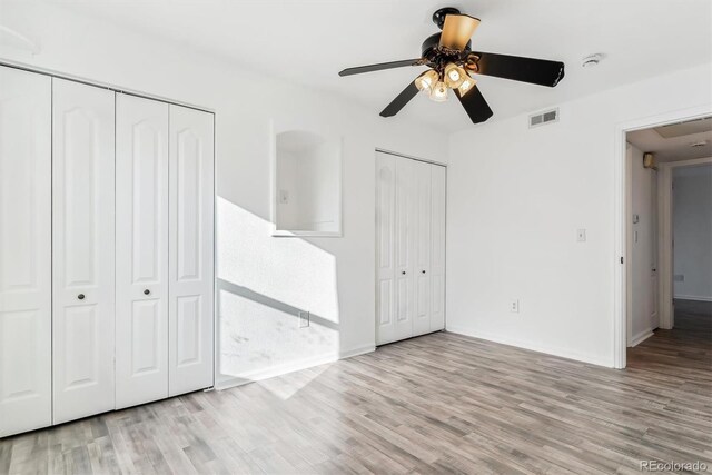 1648 S Cole St Unit B7, Lakewood, CO 80228 - unfurnished bedroom featuring multiple closets, wood finished floors, and a ceiling fan