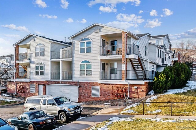 1648 S Cole St Unit B7, Lakewood, CO 80228 - view of front of house featuring an attached garage, brick siding, and driveway