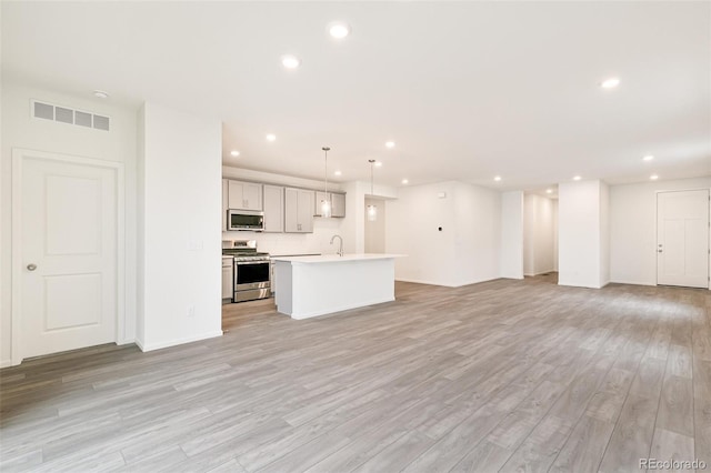 unfurnished living room featuring light hardwood / wood-style flooring and sink