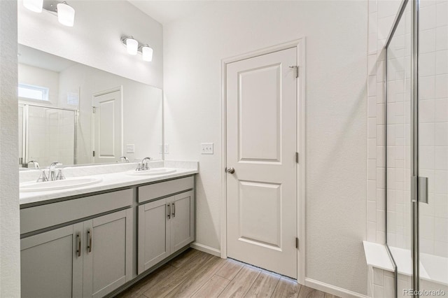 bathroom with a shower with door, vanity, and hardwood / wood-style flooring