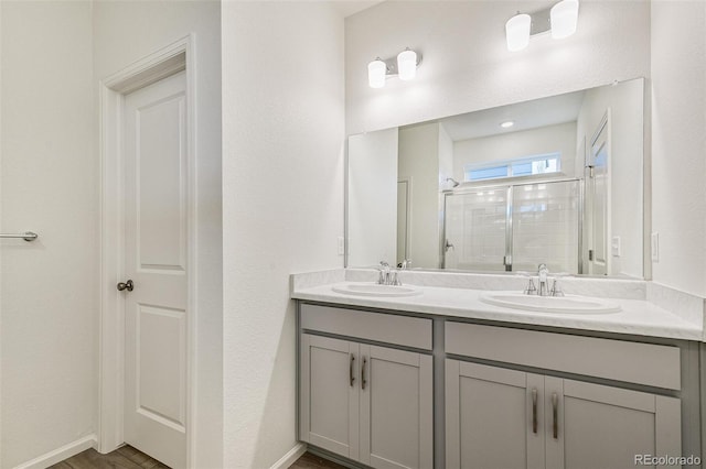 bathroom featuring vanity, an enclosed shower, and hardwood / wood-style flooring