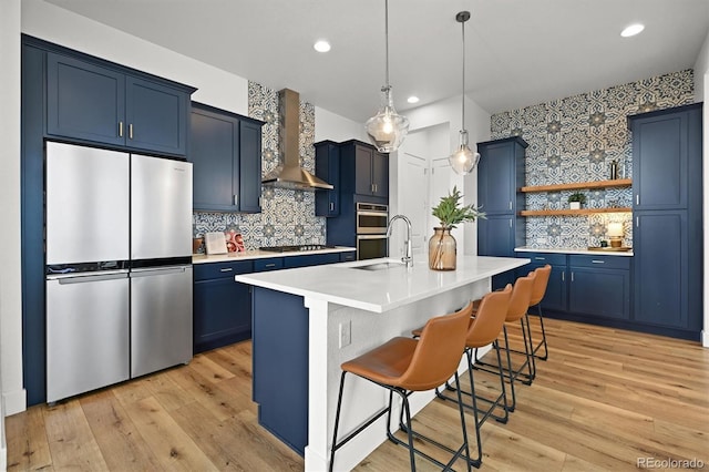 21440 E 61st Dr, Aurora, CO 80019 - kitchen with stainless steel appliances, blue cabinets, wall chimney exhaust hood, a breakfast bar, and a sink