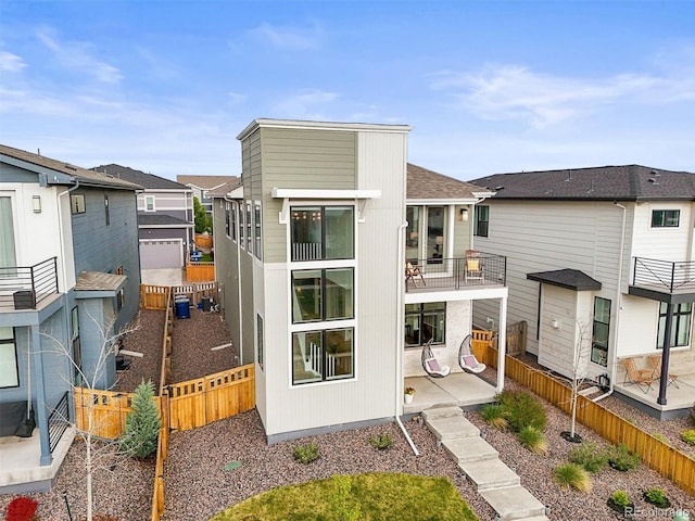 21440 E 61st Dr, Aurora, CO 80019 - back of property featuring a fenced backyard, a shingled roof, a residential view, a patio area, and a balcony