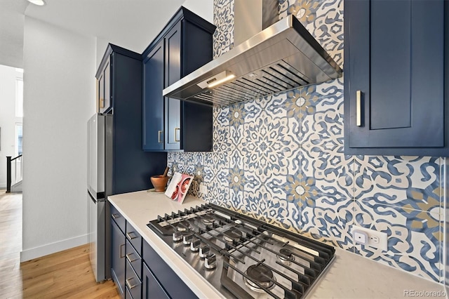 21440 E 61st Dr, Aurora, CO 80019 - kitchen featuring wall chimney exhaust hood, stainless steel gas stovetop, baseboards, light countertops, and light wood finished floors