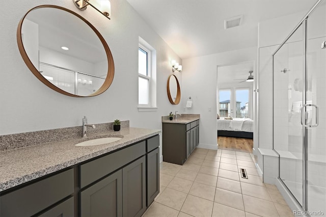 21440 E 61st Dr, Aurora, CO 80019 - full bath with a shower stall, ceiling fan, tile patterned flooring, two vanities, and connected bathroom