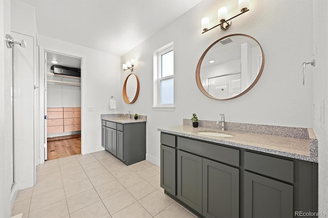 21440 E 61st Dr, Aurora, CO 80019 - full bath with tile patterned floors, two vanities, baseboards, and a shower