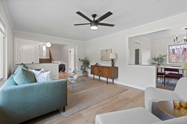 10801 W 29th Ave, Lakewood, CO 80215 - living room featuring crown molding, light wood-style flooring, ceiling fan with notable chandelier, and a wealth of natural light