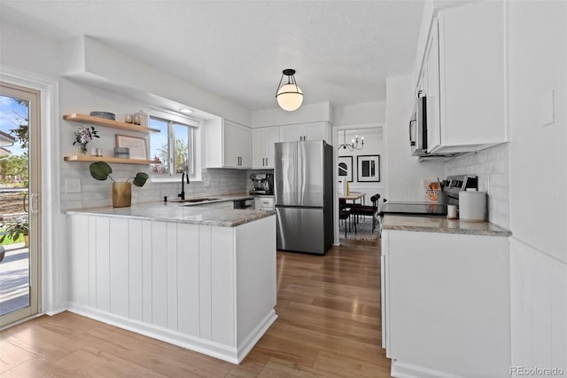 10801 W 29th Ave, Lakewood, CO 80215 - kitchen with backsplash, stainless steel appliances, a sink, and a peninsula