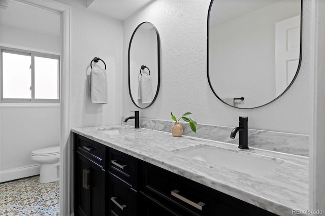 10801 W 29th Ave, Lakewood, CO 80215 - bathroom featuring a sink, baseboards, toilet, and double vanity
