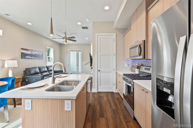 1530 Terry St, Longmont, CO 80501 - kitchen with appliances with stainless steel finishes, open floor plan, light countertops, light brown cabinets, and dark wood-style flooring