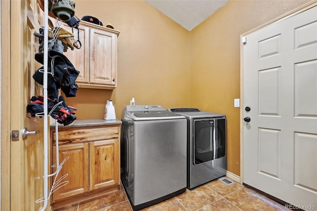 1625 N Yoder Rd, Yoder, CO 80864 - laundry area with cabinet space, washing machine and clothes dryer, light tile patterned floors, and a textured ceiling