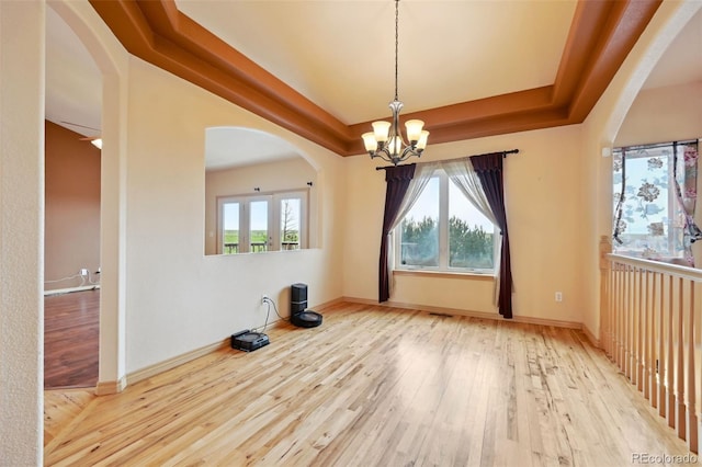 1625 N Yoder Rd, Yoder, CO 80864 - unfurnished dining area with a chandelier, wood-type flooring, arched walkways, and baseboards