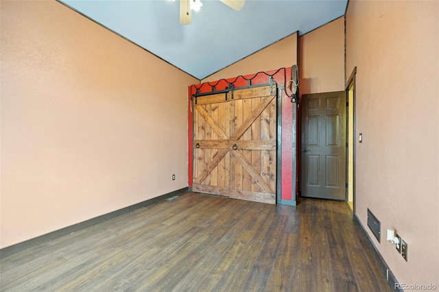 1625 N Yoder Rd, Yoder, CO 80864 - unfurnished bedroom featuring wood finished floors, lofted ceiling, a barn door, baseboards, and ceiling fan