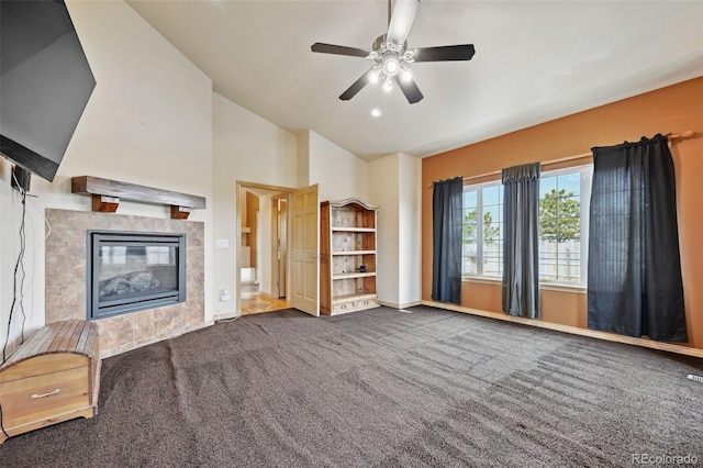 1625 N Yoder Rd, Yoder, CO 80864 - unfurnished living room with carpet, ceiling fan, baseboards, a tiled fireplace, and high vaulted ceiling