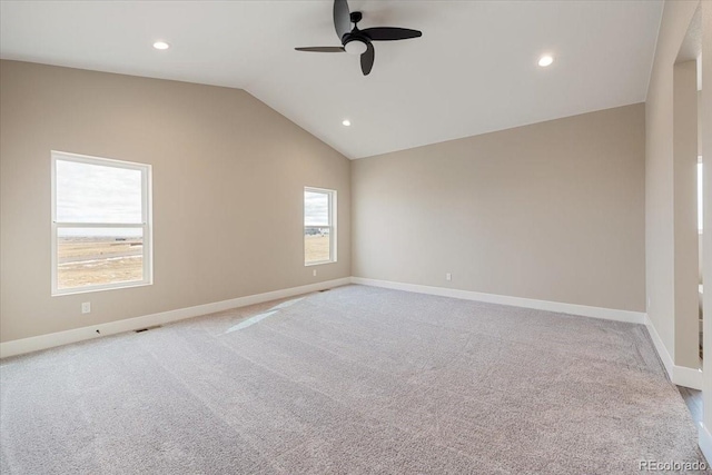 carpeted spare room with vaulted ceiling and ceiling fan