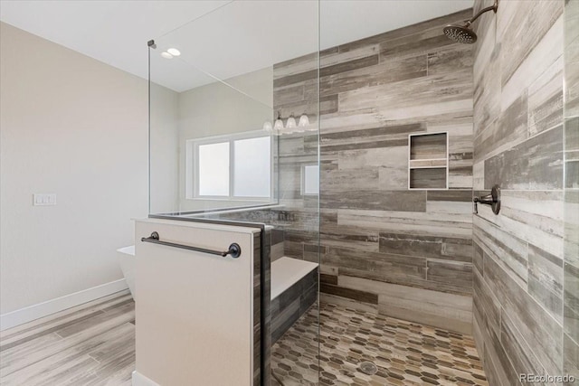 bathroom with wood-type flooring and tiled shower