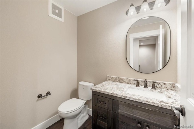 bathroom with vanity, hardwood / wood-style floors, and toilet