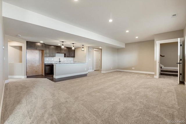 unfurnished living room featuring carpet floors and sink