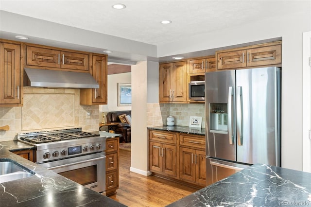 4810 W 102nd Pl, Westminster, CO 80031 - kitchen with appliances with stainless steel finishes, under cabinet range hood, brown cabinets, recessed lighting, and light wood-style floors