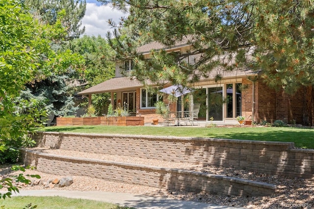 4810 W 102nd Pl, Westminster, CO 80031 - rear view of house featuring a lawn, brick siding, and a patio area