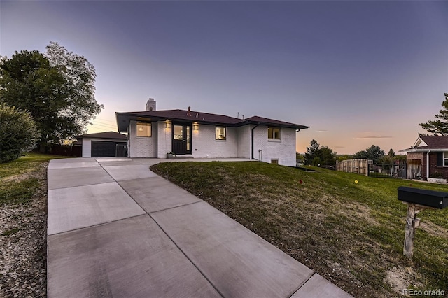 view of front of house featuring a yard, an outbuilding, and a garage