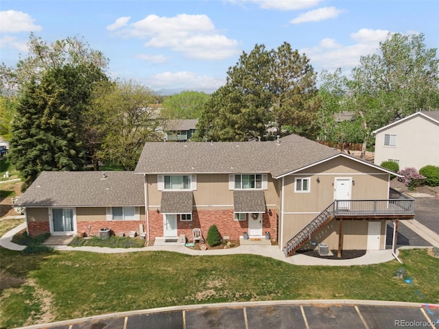 2271 Coronado Pkwy N Unit D, Denver, CO 80229 - view of front of home with uncovered parking, a front lawn, roof with shingles, a wooden deck, and brick siding