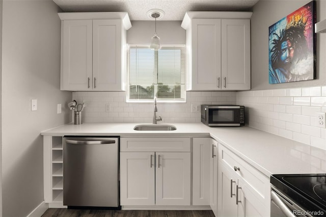 2271 Coronado Pkwy N Unit D, Denver, CO 80229 - kitchen featuring stainless steel appliances, a sink, decorative backsplash, white cabinets, and light countertops