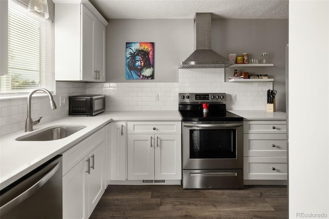 2271 Coronado Pkwy N Unit D, Denver, CO 80229 - kitchen with stainless steel appliances, wall chimney range hood, a sink, light countertops, and a textured ceiling