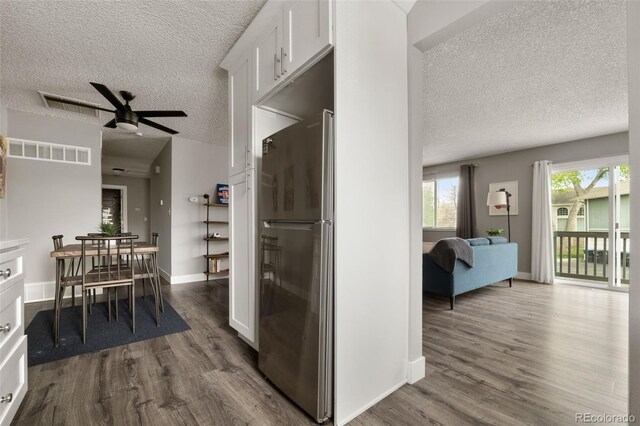 2271 Coronado Pkwy N Unit D, Denver, CO 80229 - kitchen with freestanding refrigerator, a textured ceiling, dark wood-type flooring, white cabinetry, and a ceiling fan