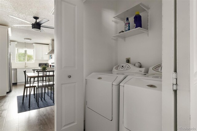 2271 Coronado Pkwy N Unit D, Denver, CO 80229 - laundry area featuring washing machine and clothes dryer, a textured ceiling, a ceiling fan, and light wood-type flooring