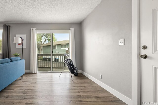 2271 Coronado Pkwy N Unit D, Denver, CO 80229 - sitting room featuring wood finished floors, a textured ceiling, and baseboards