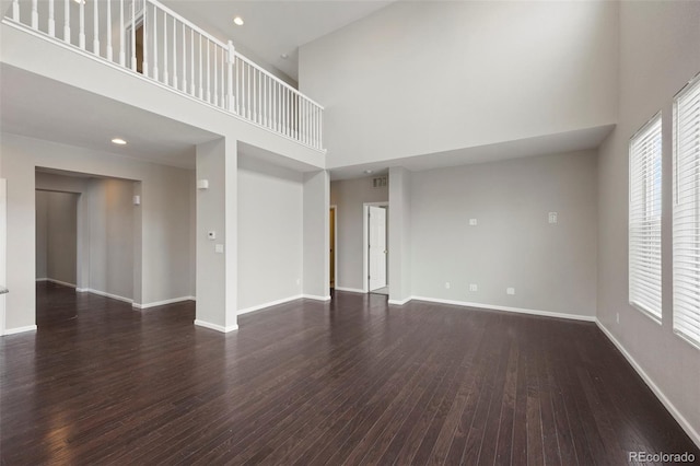 1523 Honeysuckle Ct, Brighton, CO 80601 - unfurnished living room featuring a high ceiling, dark wood-style flooring, and baseboards