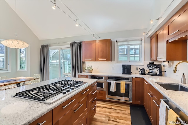 4861 Curie Ct, Boulder, CO 80301 - kitchen featuring appliances with stainless steel finishes, a sink, light stone counters, track lighting, and brown cabinetry