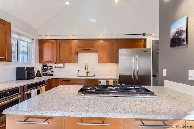 4861 Curie Ct, Boulder, CO 80301 - kitchen featuring appliances with stainless steel finishes, brown cabinets, decorative backsplash, lofted ceiling, and light stone counters