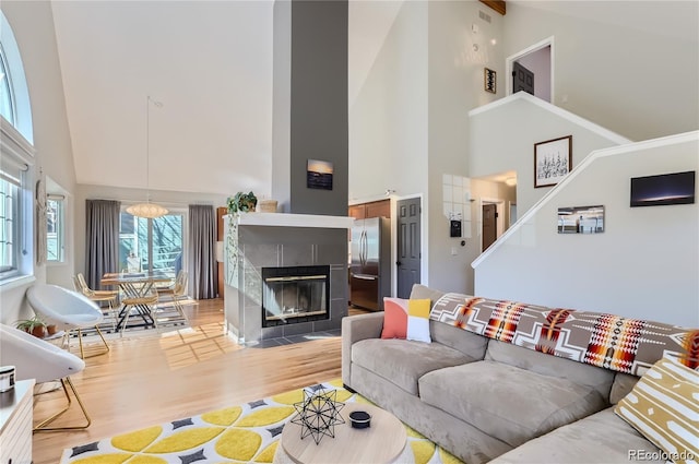 4861 Curie Ct, Boulder, CO 80301 - living area with high vaulted ceiling, light wood-style floors, stairway, and a fireplace