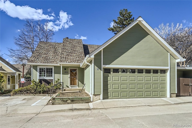 4861 Curie Ct, Boulder, CO 80301 - view of front of home featuring a garage, a chimney, and concrete driveway