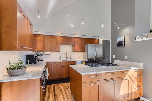 4861 Curie Ct, Boulder, CO 80301 - kitchen with appliances with stainless steel finishes, track lighting, light stone counters, backsplash, and light wood-type flooring