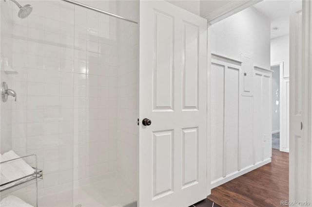 bathroom with hardwood / wood-style flooring and a tile shower