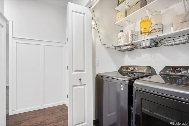 clothes washing area with washer and clothes dryer and dark wood-type flooring