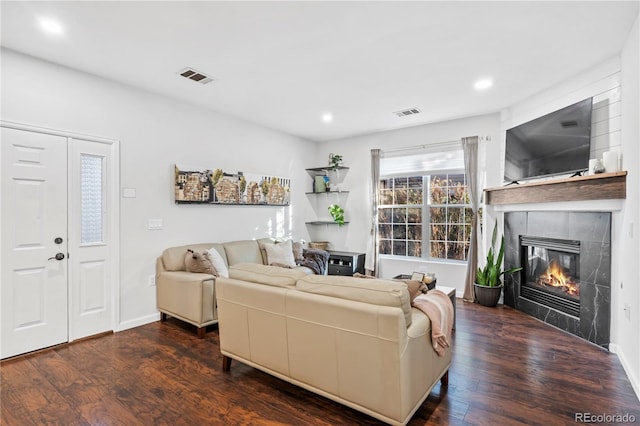 living room featuring dark hardwood / wood-style floors and a tile fireplace