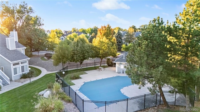 view of swimming pool featuring a patio area, a yard, and an outdoor structure