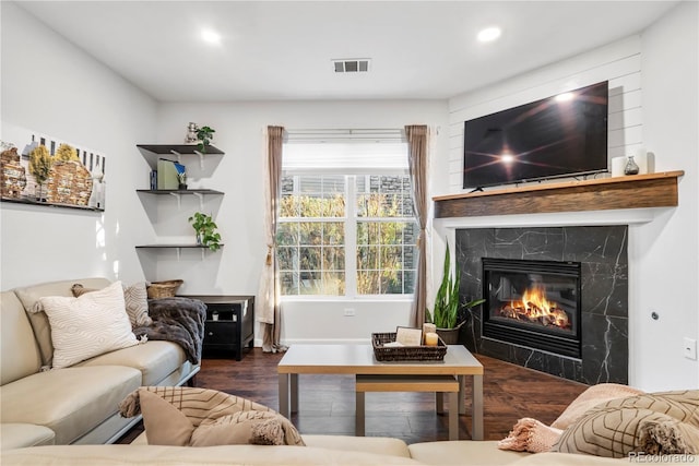 living room with dark wood-type flooring and a high end fireplace