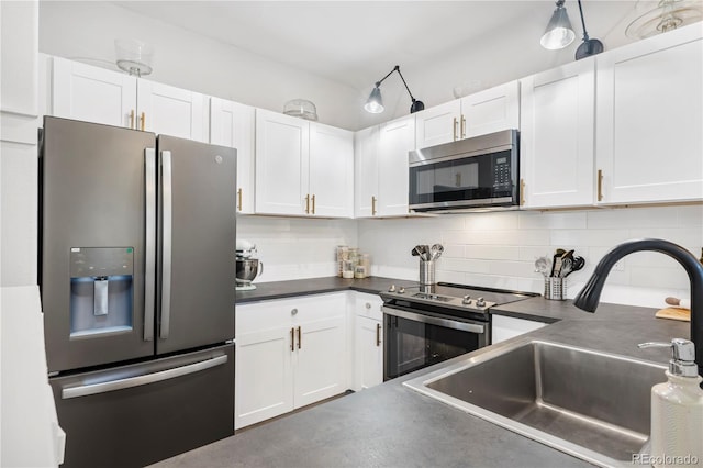 kitchen featuring appliances with stainless steel finishes, decorative backsplash, white cabinets, and sink