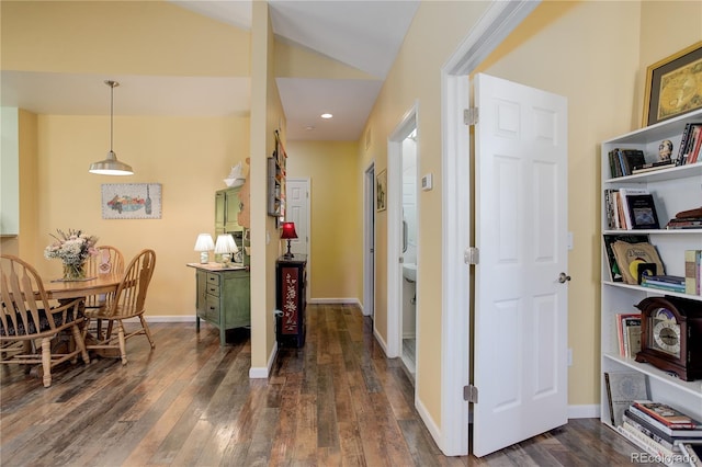 hall with lofted ceiling, dark wood-style flooring, and baseboards