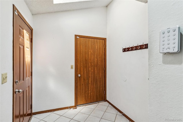 interior space with a textured ceiling and light tile patterned floors