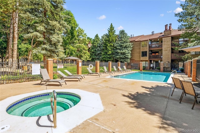 view of swimming pool with a hot tub and a patio