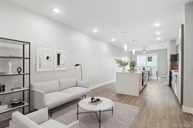 living room with light wood finished floors, baseboards, and recessed lighting