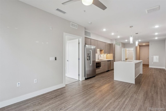 kitchen with appliances with stainless steel finishes, wood finished floors, and visible vents