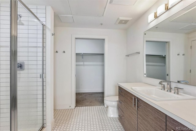 full bath featuring a spacious closet, a shower stall, toilet, and vanity